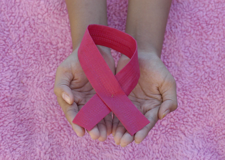formato palestra outubro rosa sipat acoes institucionais Mãos segurando o laço rosa, símbolo da campanha Outubro Rosa